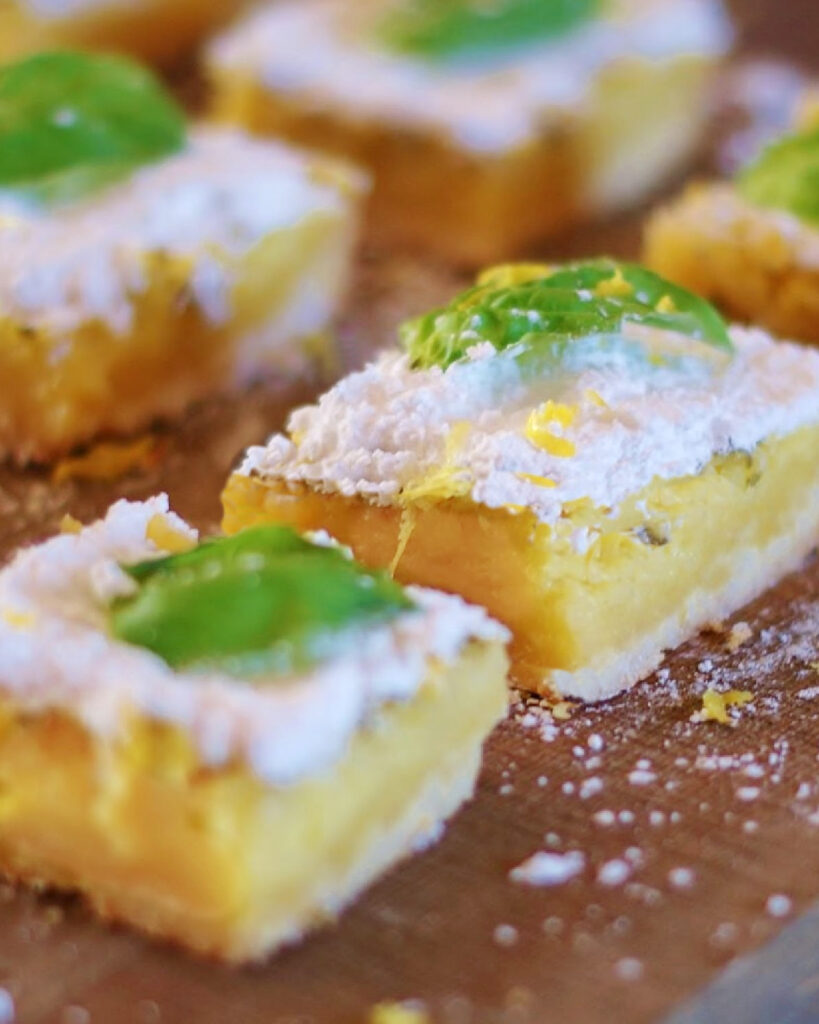 Two lemon squares from the side to show the texture of the set lemon custard filling.