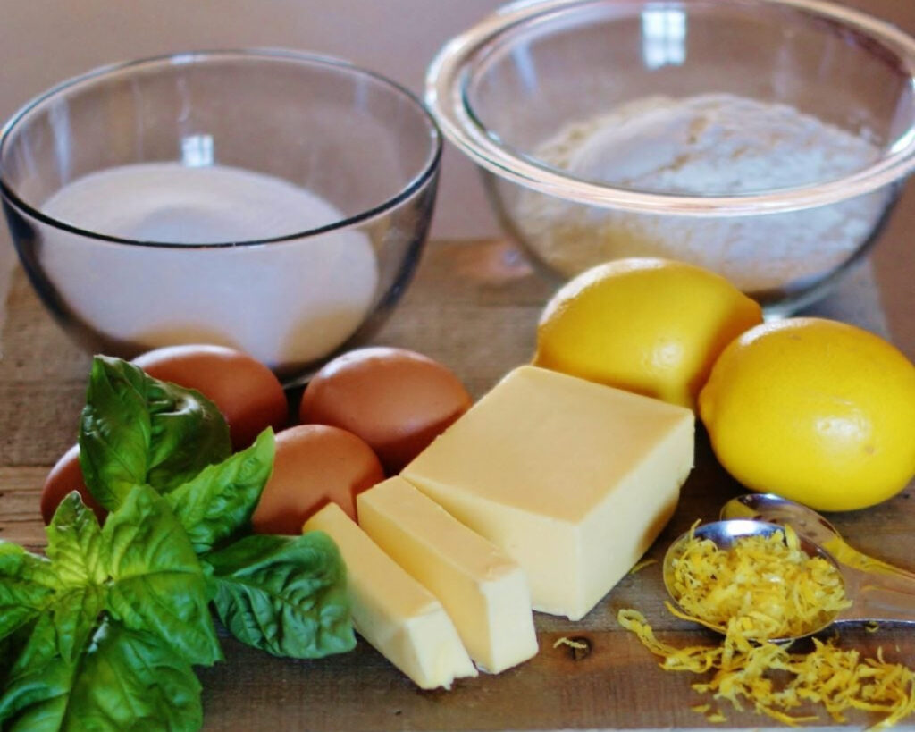 A visual of the basic pantry ingredients needed to make this lemon dessert, including flour, sugar, eggs, butter and lemons, so readers can easily recognize them.
