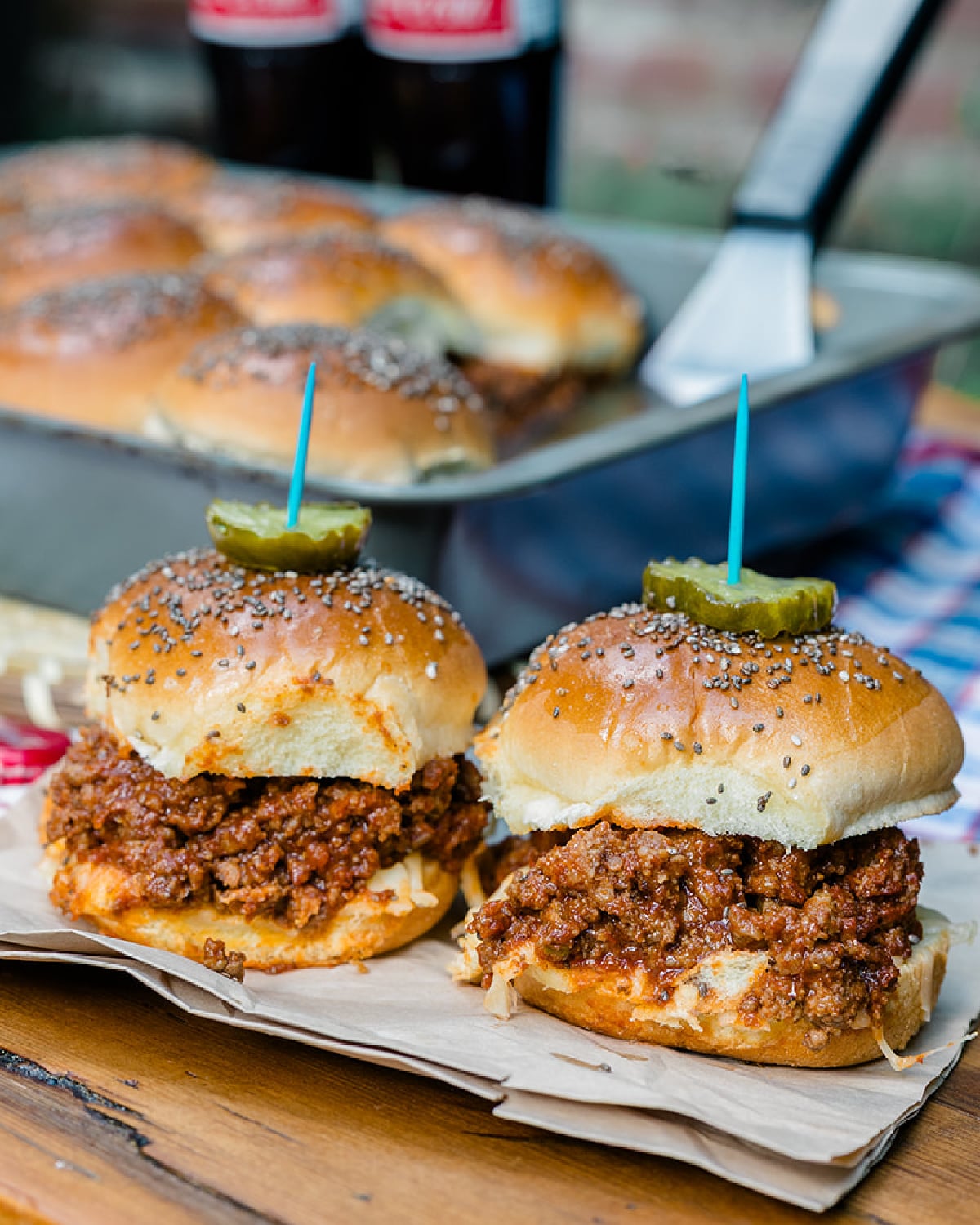 The best homemade sloppy joe slider recipe topped with pickles and a party toothpick.