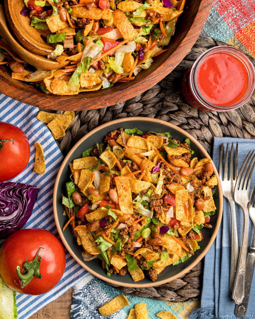 A plate full of this retro frito taco salad with ranch style beans and taco meat.