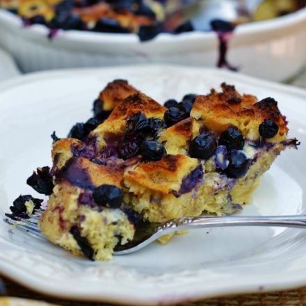 A slice of blueberry breakfast bake on a white plate with a yellow napkin.