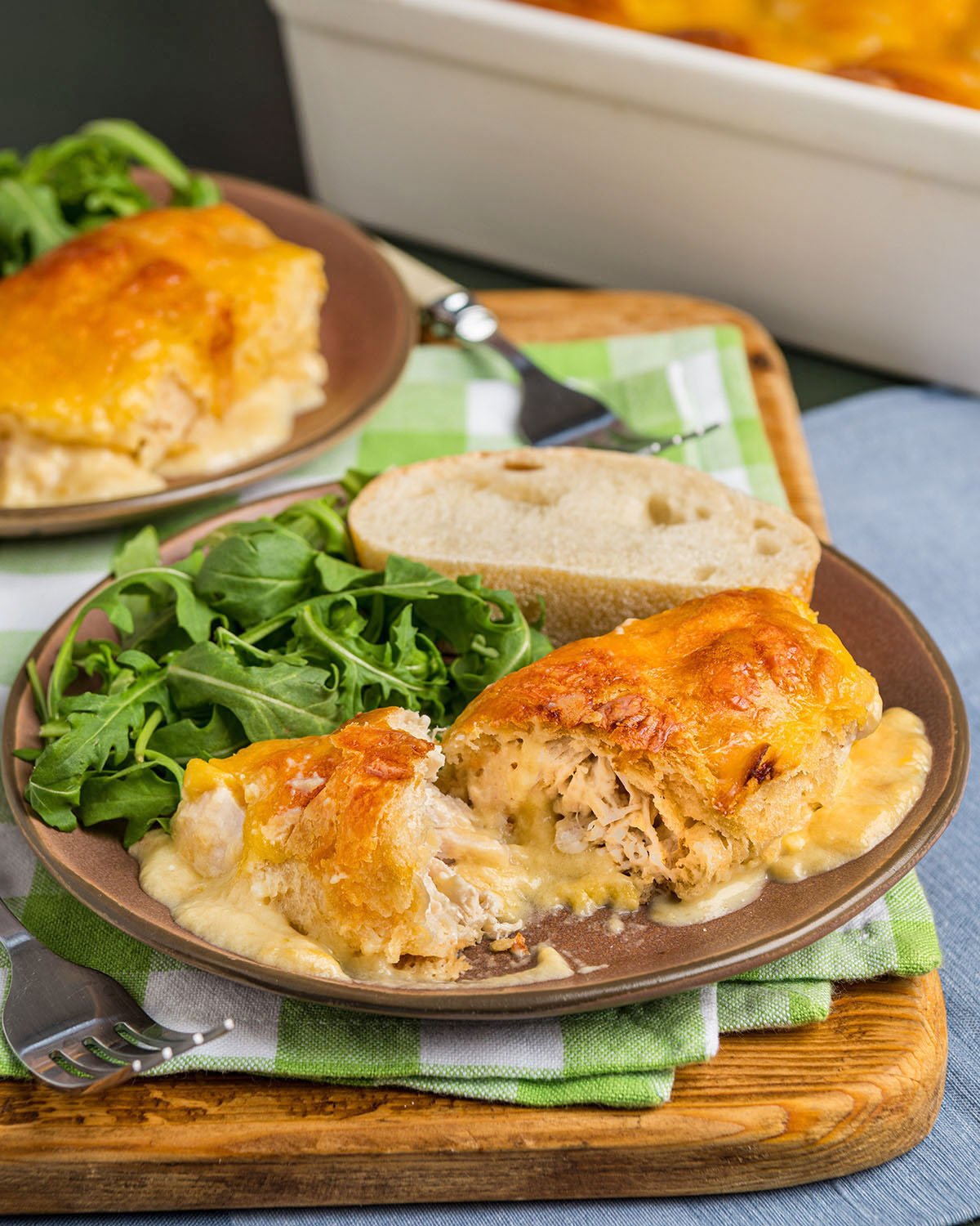 Pillsbury crescent rolls stuffed with chicken and cream cheese on a plate with bread and salad as a dinner idea.