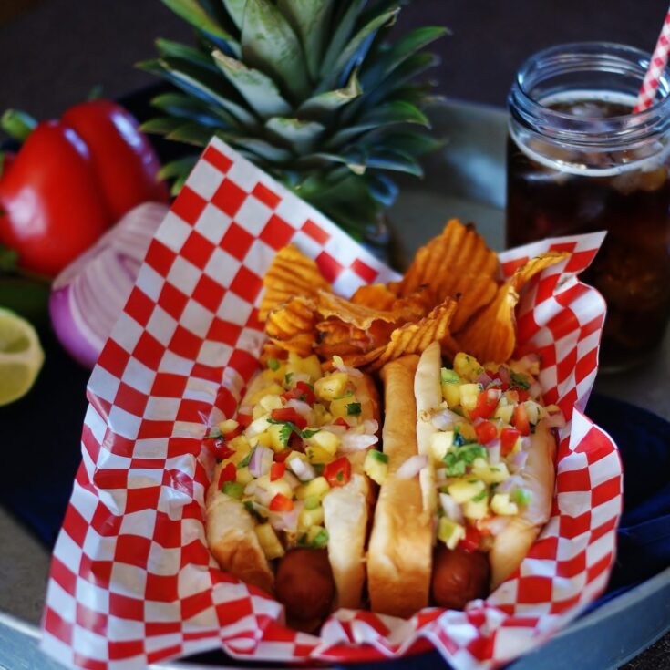 Grilled hot dogs with pineapple relish in a picnic basket.