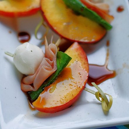 A summer appetizer treat of peaches, ham, mozzarella and basil