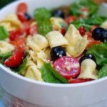 A close up of a bowl of tortellini pasta salad.