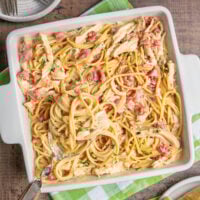 A square casserole dish fulled of spaghetti, white chicken meat, cheese and Rotel tomatoes