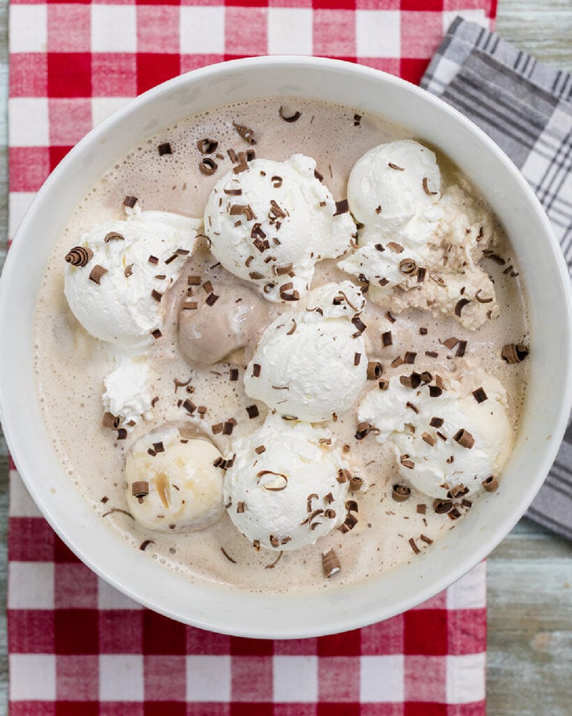 A finished bowl of southern coffee punch made with strong coffee, chocolate and vanilla ice creams, topped with scoops of real whipped cream and dark chocolate shavings.