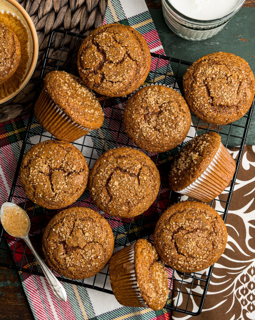 Looking down on the tops of a batch of homemade gingerbread muffins to show the texture of their crackle, bakery style tops.