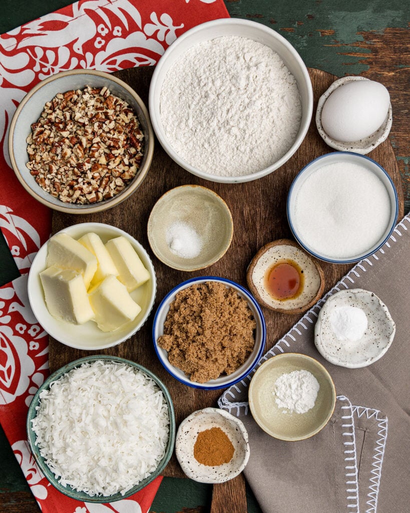 The ingredients and pantry staples needed to make baked coconut cookies with pecans.