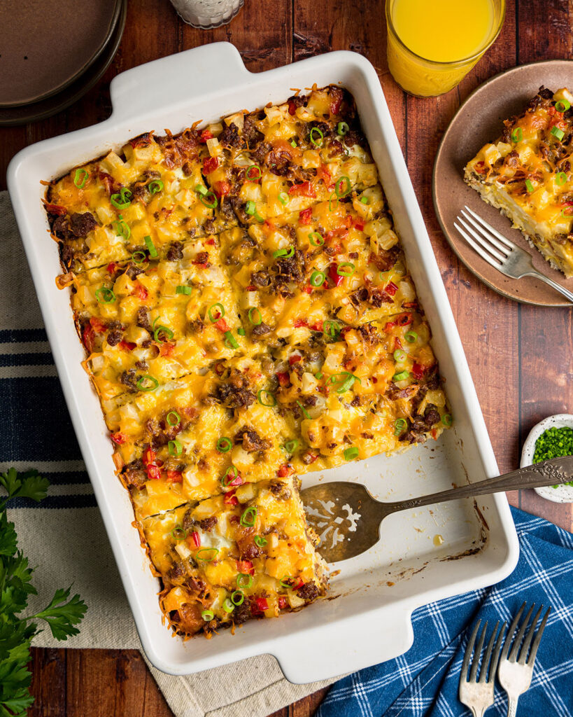 A baked hash brown casserole with egg and sausage and peppers sliced and ready to serve, showing how it would appear at breakfast or brunch.