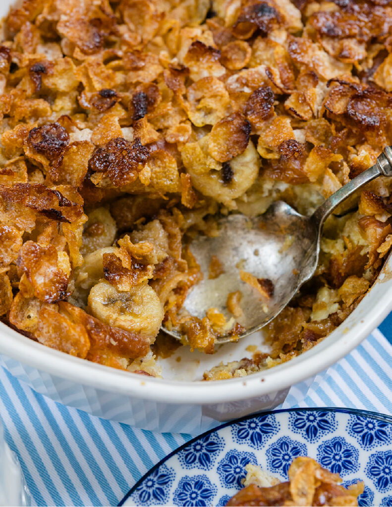 An upclose look at this french toast casserole with bananas and frosted corn flakes.