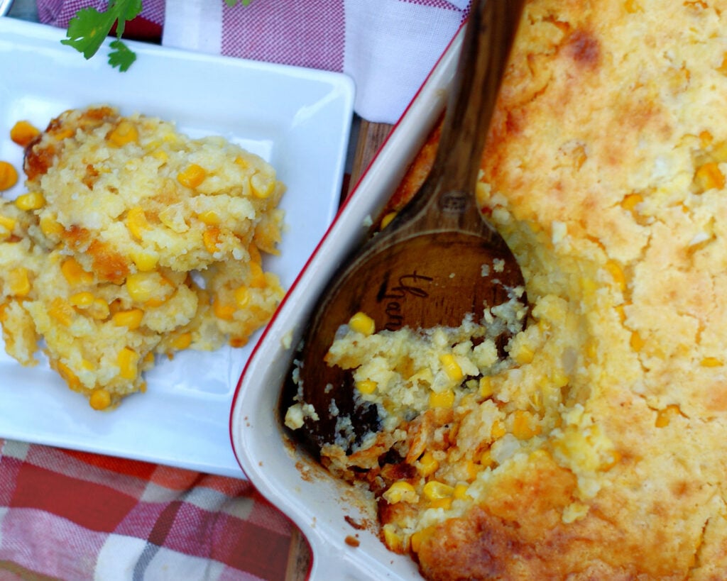 Southern corn pudding on a plate and served from a casserole dish to show how it would look at the Thanksgiving table.