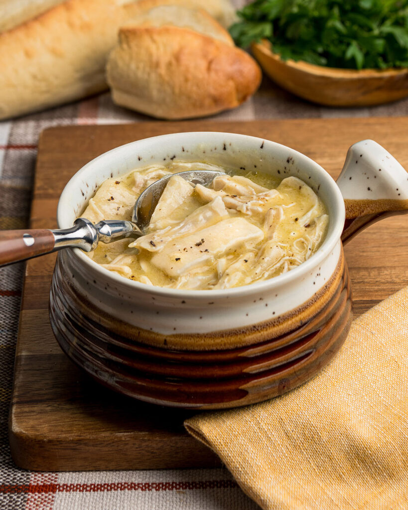 A bowl of flat dumplings and chicken for a hearty dinner.