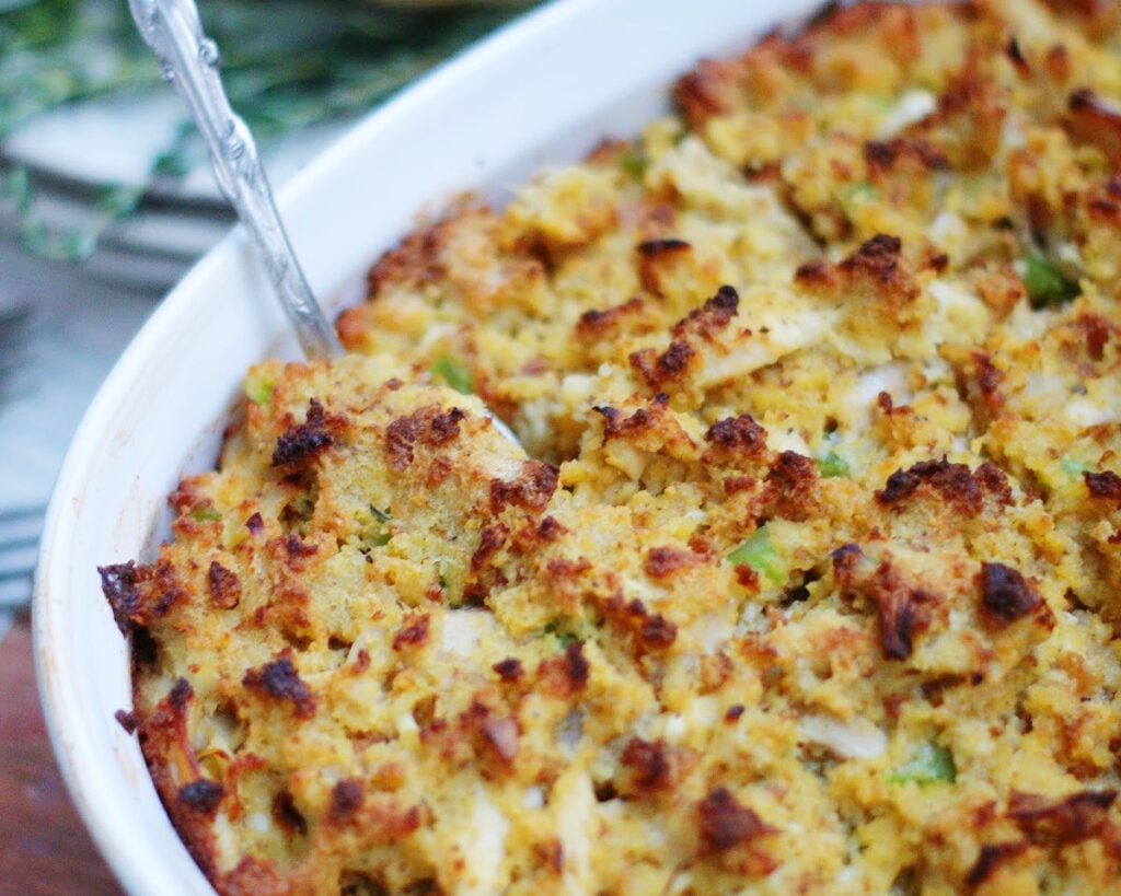 Up close of a baked pan of cornbread dressing with chicken to show texture and ingredients after baking.