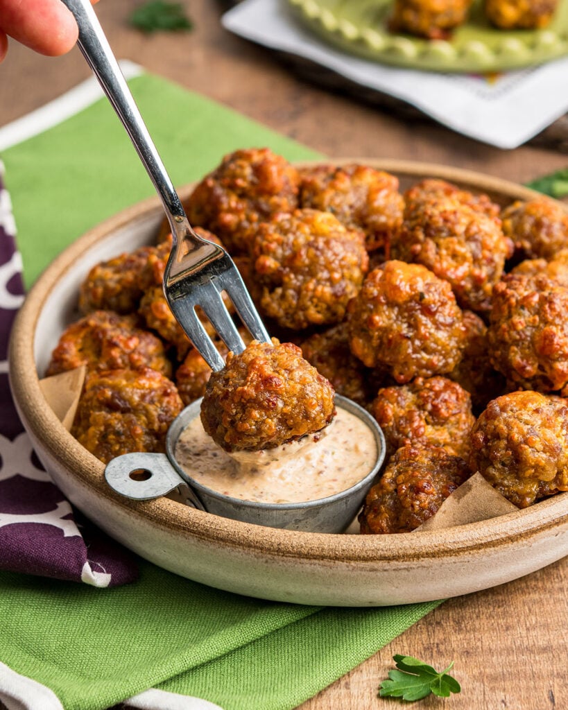 Dunking Creole sausage balls in Louisiana Remoulade sauce as a snack.