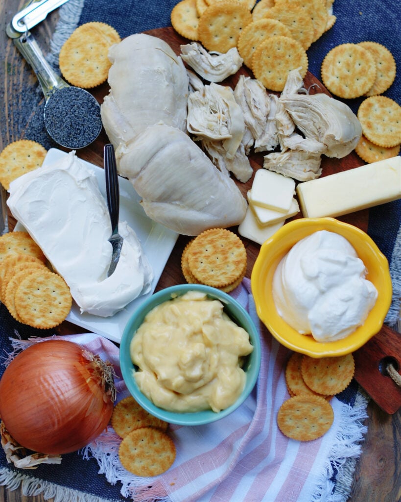 ingredients for poppy seed chicken casserole including cream cheese and a ritz cracker topping