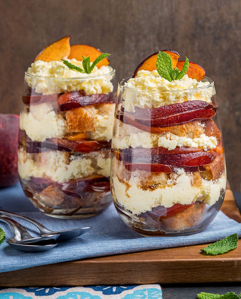 Old fashioned peach trifles made in 2 cups as individual desserts with fresh peaches, toasted pound cake and a light vanilla cream.