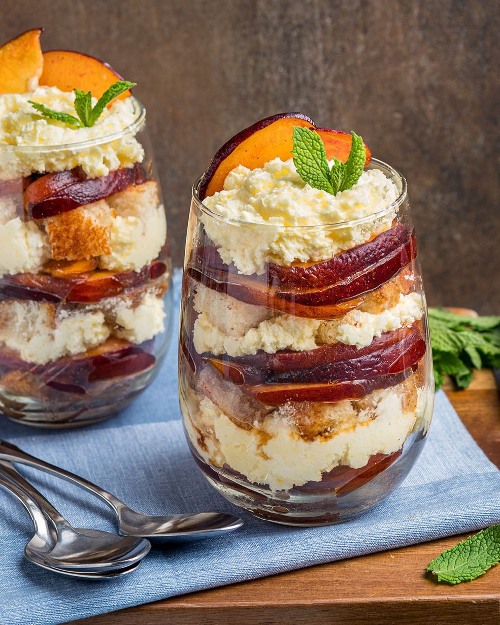 A close look at an individual peaches and cream trifle made with toasted pound cake to show the layers and texture of this easy dessert.