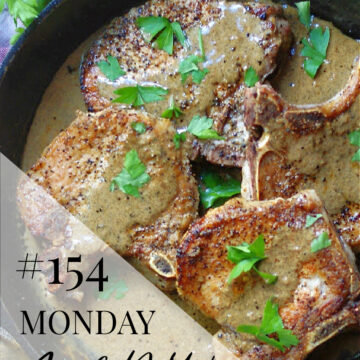a skillet with smothered pork chops with a text overlay of Monday Menu #154 as this week's meal plan feature recipe.
