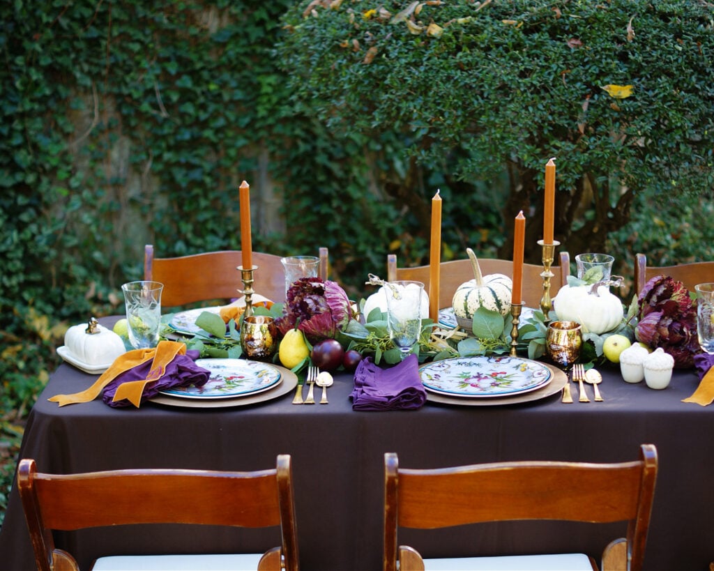 Thanksgiving table ideas with copper, purple and brown and a low fruit centerpiece.