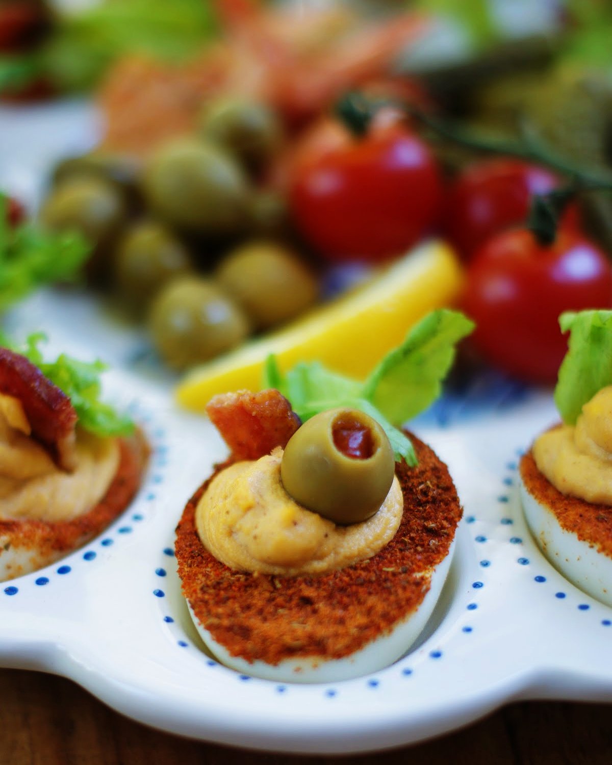 A deviled egg made with b loody Mary seasonings and topped with Bloddy Mary garnishes.