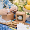 Adding "from the kitchen of" gift sticker to a bakery box of cookies.