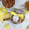 A jar of pecans with the custom Southern Discourse "from the kitchen of" gift sticker and a yellow ribbon.