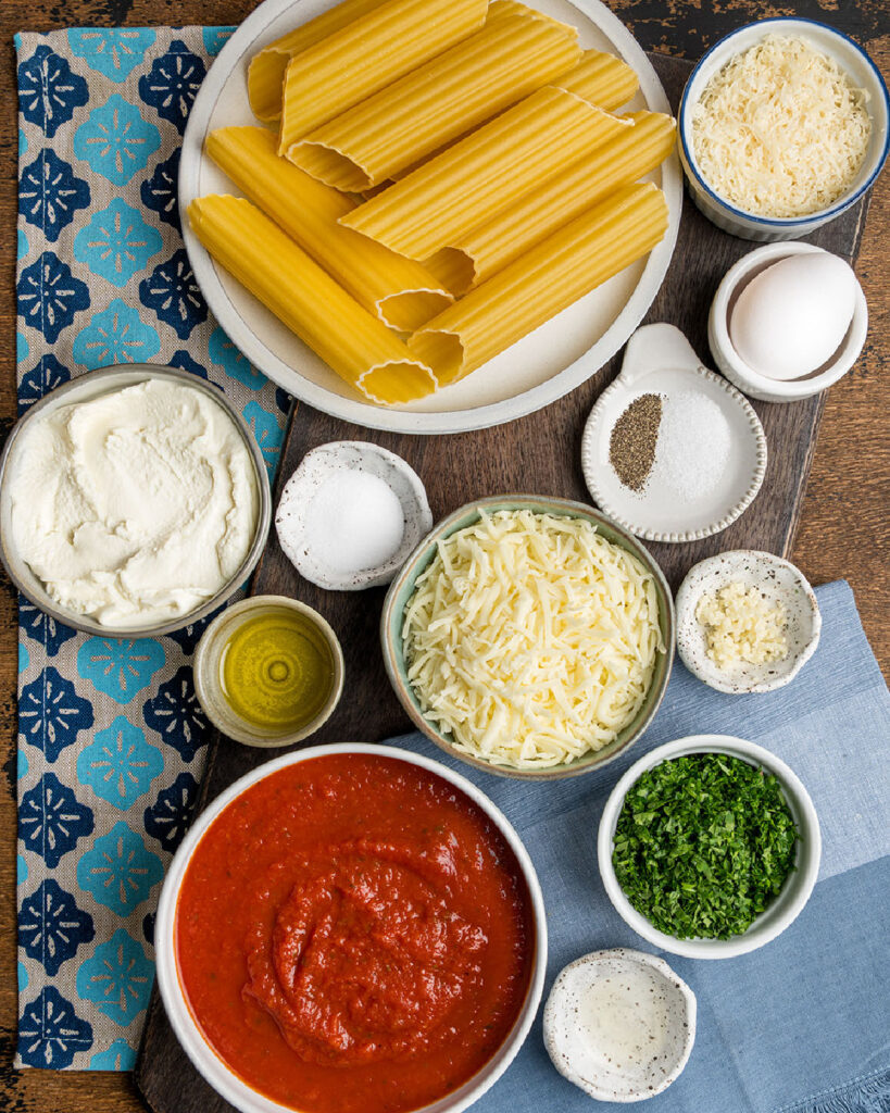 Ingredients for classic manicotti including ricotta cheese, tomatoes sauce.