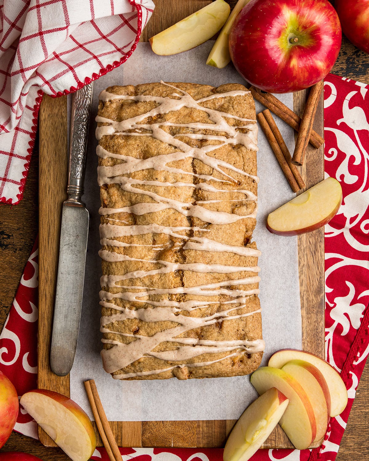 A warm loaf of Cinnamon Apple Quick Bread with cinnamon sugar glaze drizzled on top to show what the bread looks like fresh from the oven.