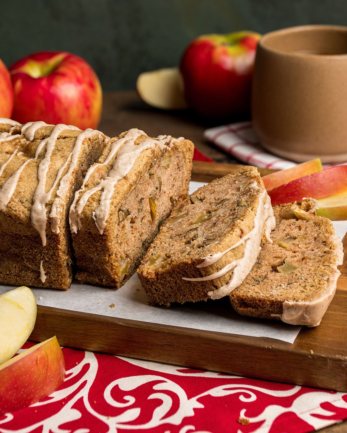 An apple loaf sliced and viewed from the side to show how it slices, the texture, or crumb, and glaze drizzle.