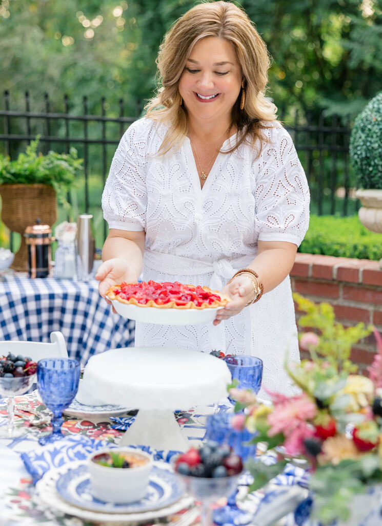 The hostess bringing pies to the table to prepare for a dessert party with friends.