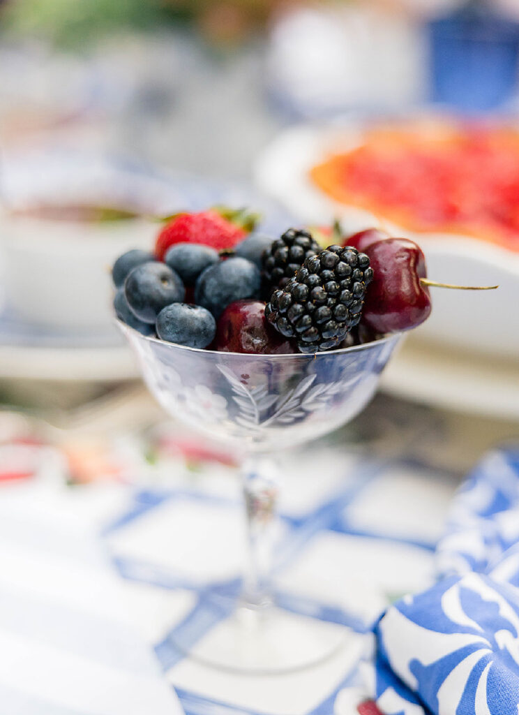 A champagne coupe filled with cherries, blueberries and strawberries is a very simple way to make each place setting feel special.