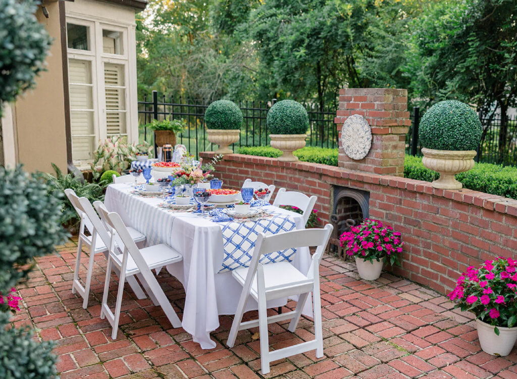 My patio filled with plants and flowers a table set for a dessert party with a few friends.