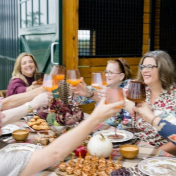 A group of friends gathered around a Thanksgiving table celebrating.